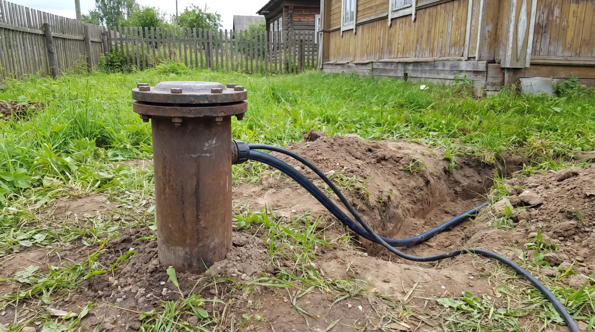Обсадная труба скважины с герметичным оголовком на участке